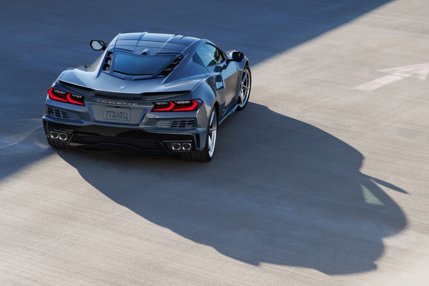 Rear end angle of 2024 Chevrolet Corvette E-Ray parked in a parking garage with shadows.