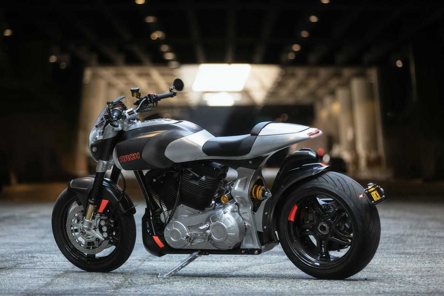 Arch Motorcycle 1s rear end side profile parked under a tunnel.