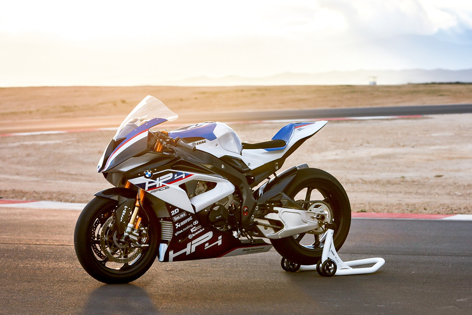 BMW HP4 Race front end angle parked on a race track with the sun setting the in back.