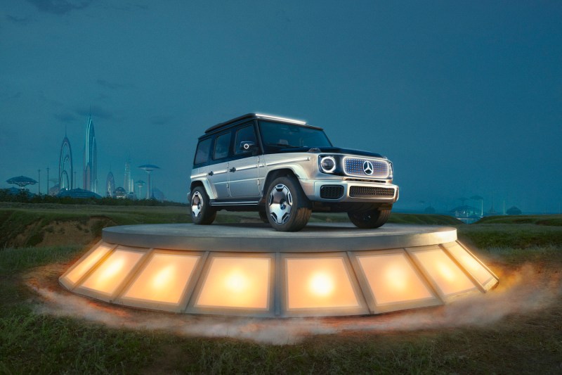 Mercedes-Benz EQG front end angle from passenger's side on a platform in front of a futuristic skyline