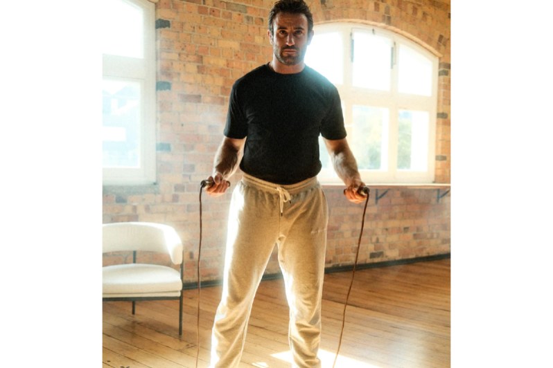 Man in sweats and jump rope.