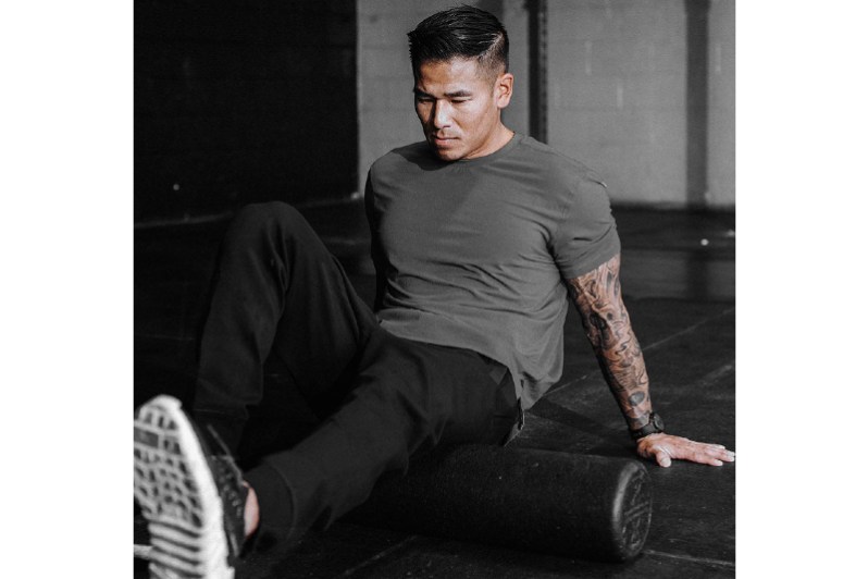 Man foam rolling in gym.