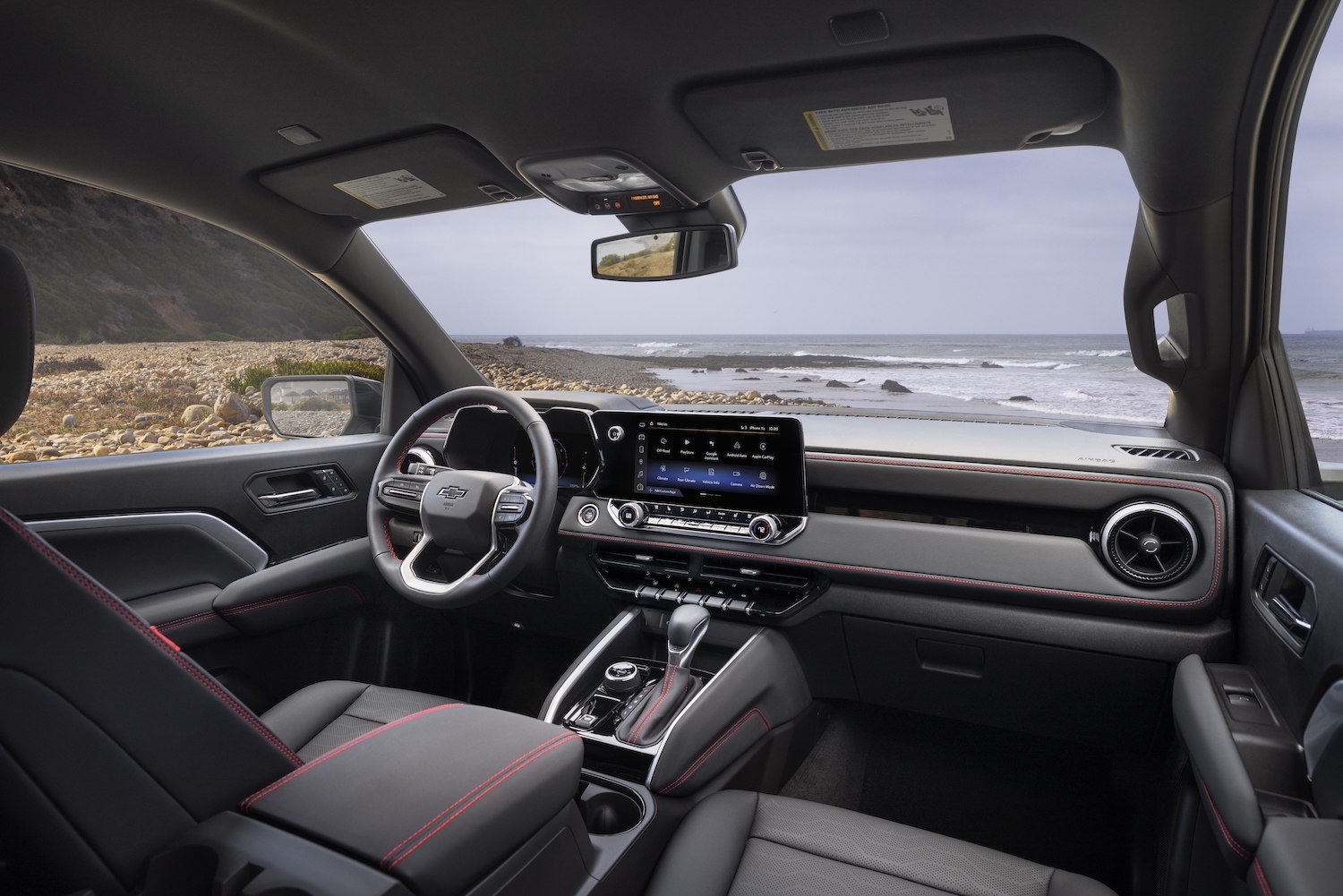 Interior of the 2023 Chevrolet Colorado from the front passenger seat with the ocean in the back.