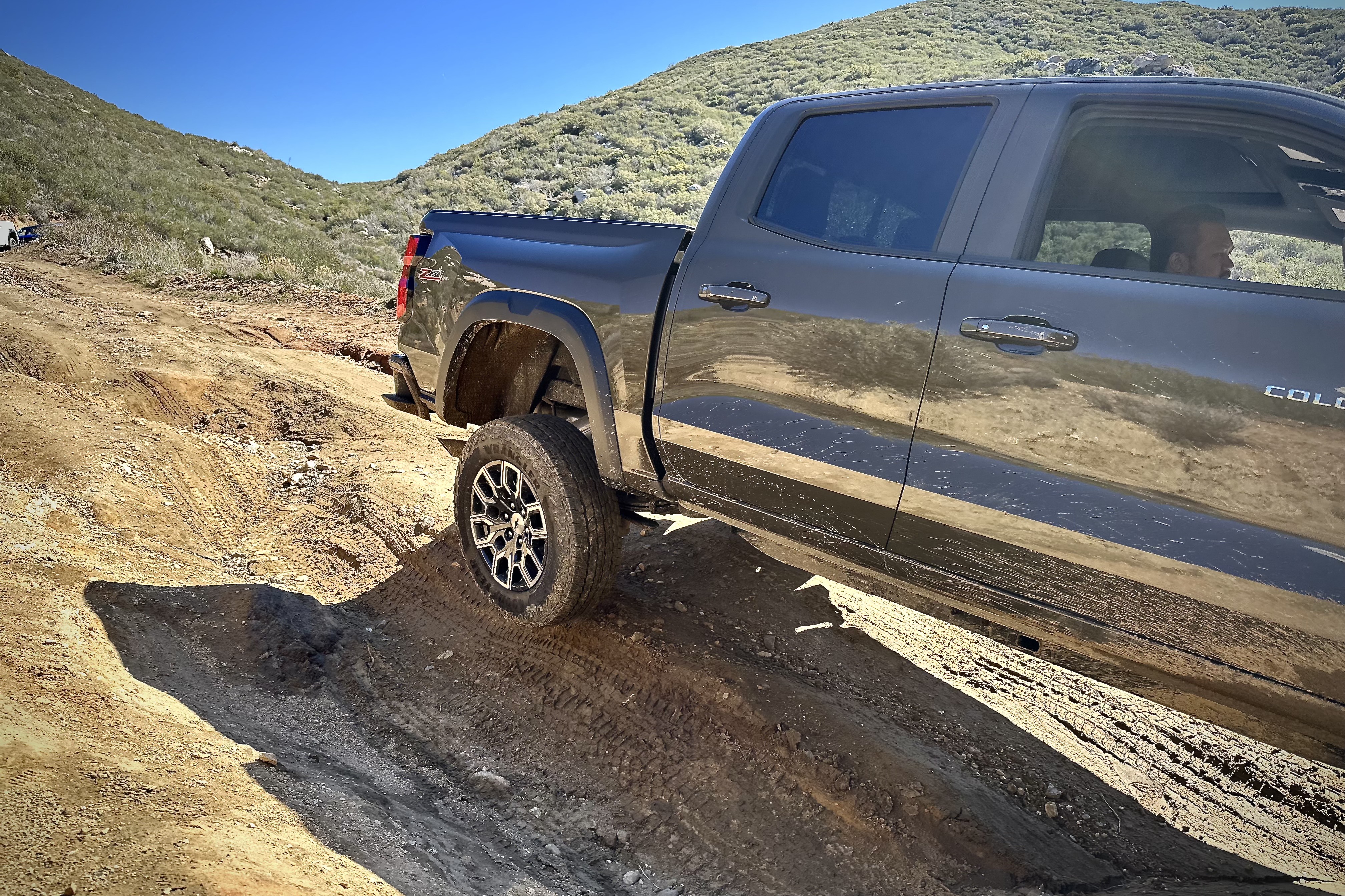 Close up of the 2023 Chevrolet Colorado Trail Boss lifting a rear wheel while off-roading.