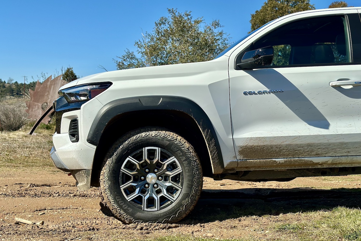 Side profile of the front end of the 2023 Chevrolet Colorado Z71 parked in a muddy field.