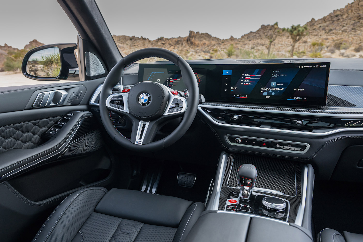 Close up of the steering wheel and dash in the 2024 BMW X5 M Competition with desert in the back.