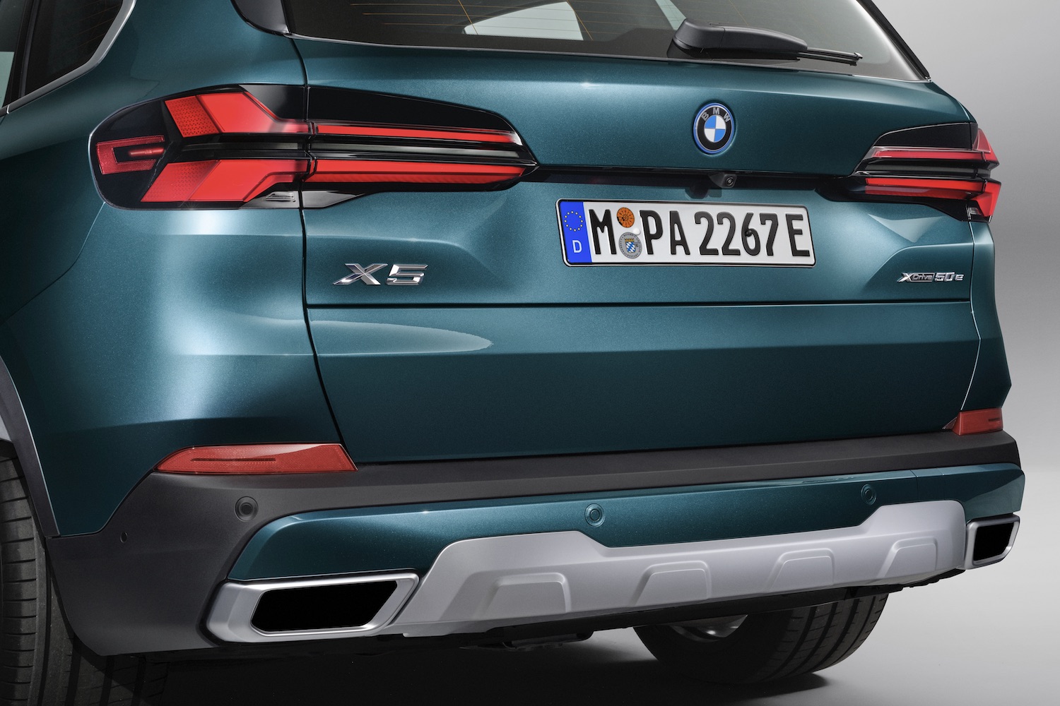 Close up of rear end of the 2024 BMW X5 xDrive50e PHEV parked in a studio.