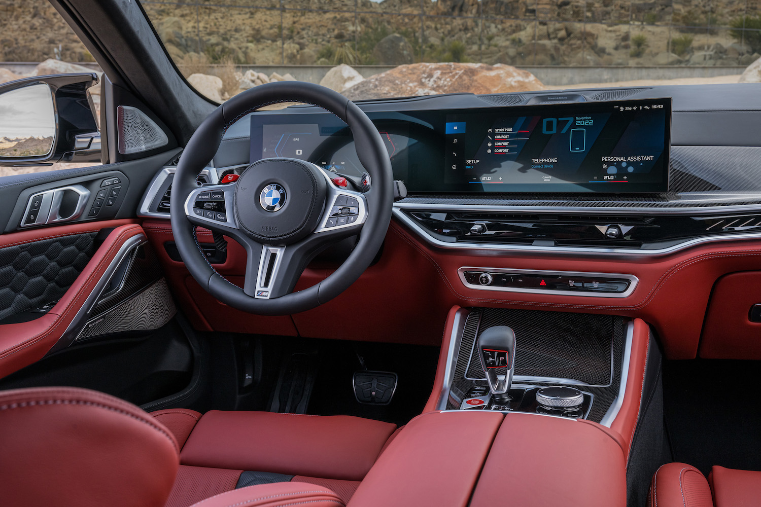 Close up of steering wheel and dashboard in the 2024 BMW X6 M Competition with desert in the back.
