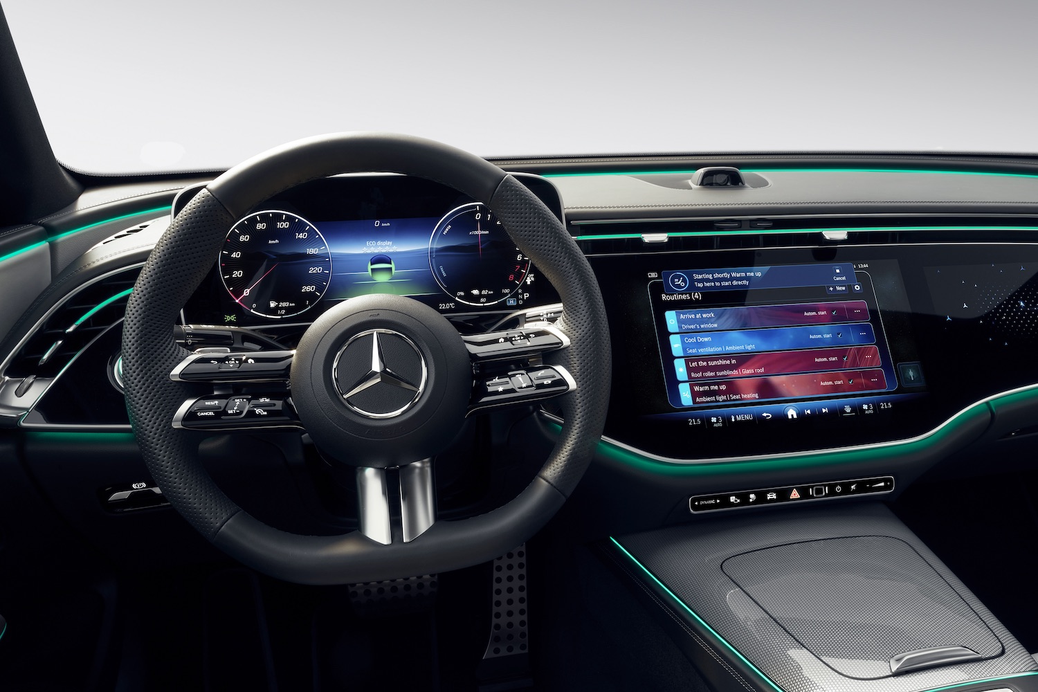Close up of steering wheel and central touchscreen in the 2024 Mercedes-Benz E-Class Superscreen.