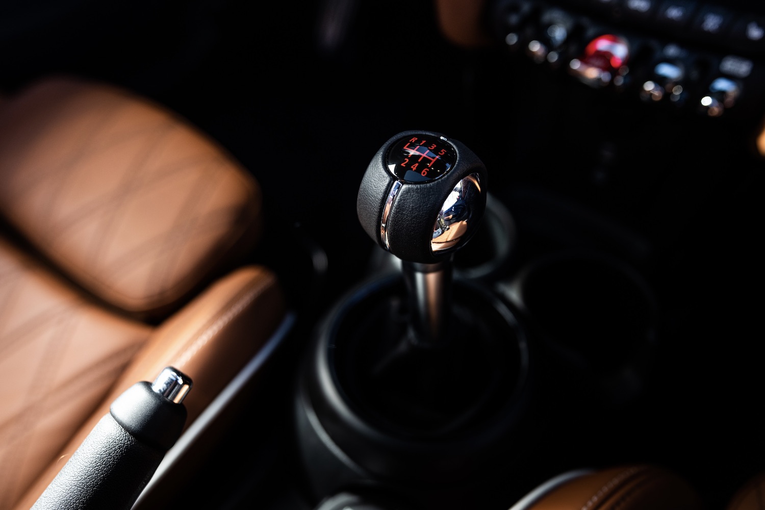 2024 Mini Cooper Family manual transmission close up with brown leather seats in the back.