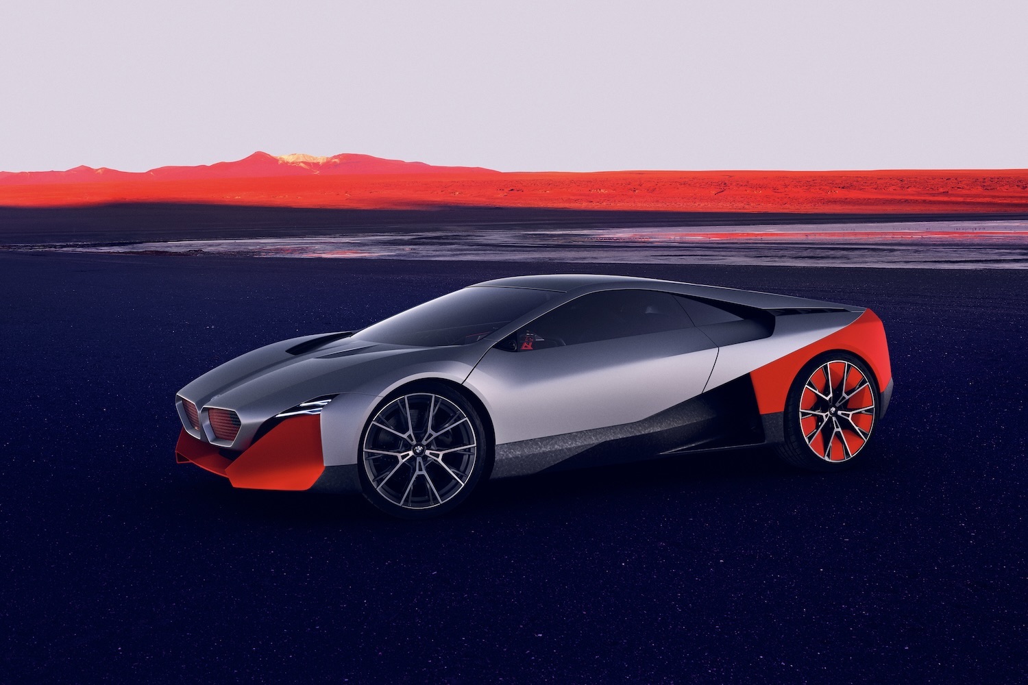 BMW M Vision NEXT Concept front end angle from driver's side in front of red mountains.