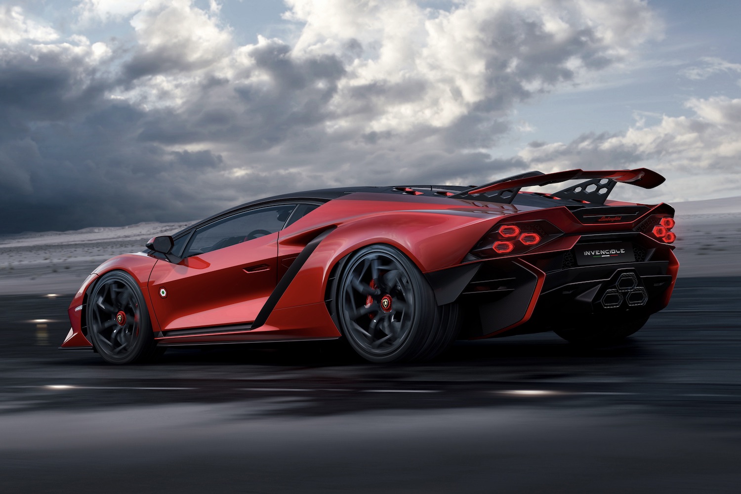 Rear end angle of Lamborghini Invencible parked on damp tarmac with dark clouds in the back.