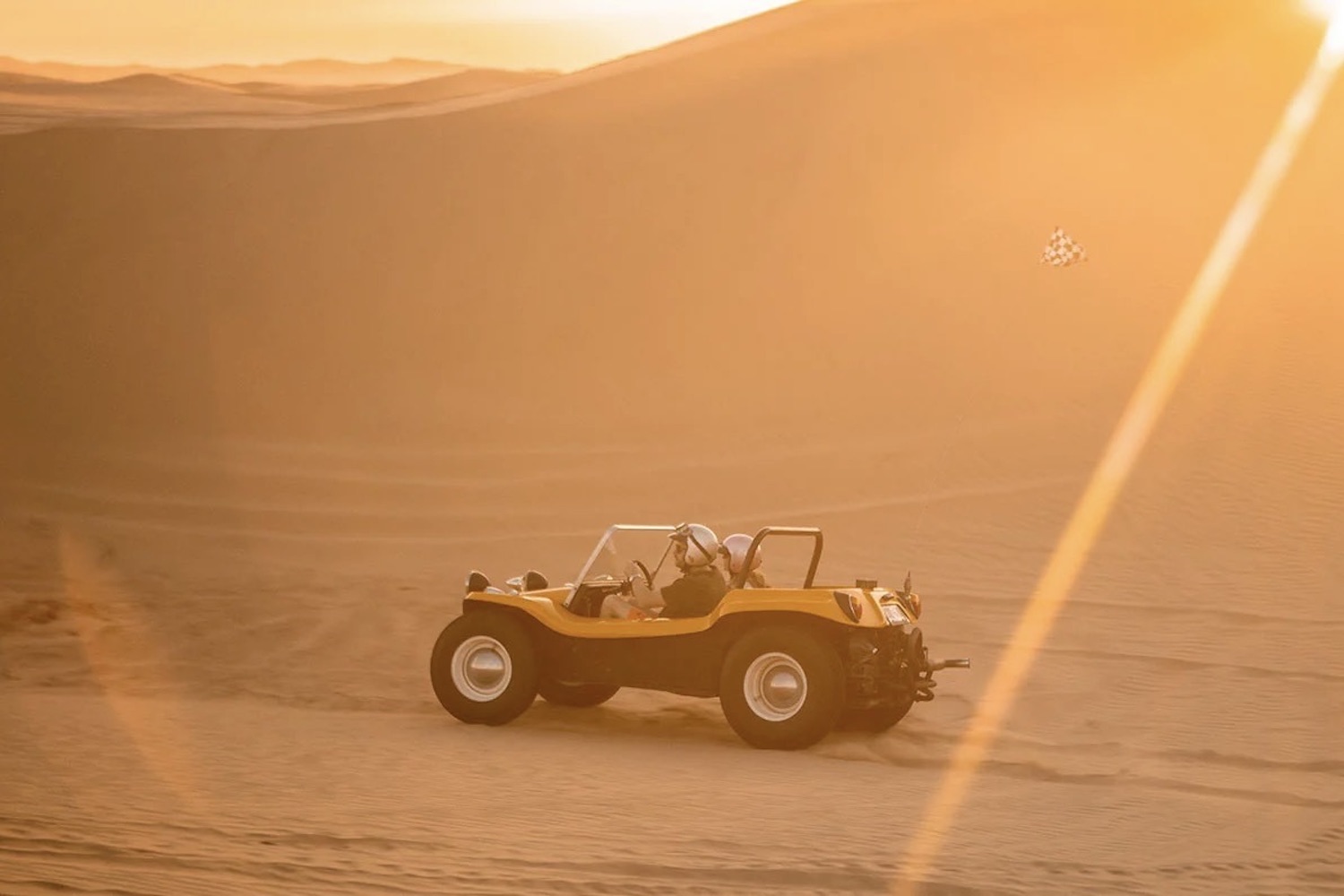 Side profile view of the Meyers Manx Remastered Kit driving along beach sand dunes.