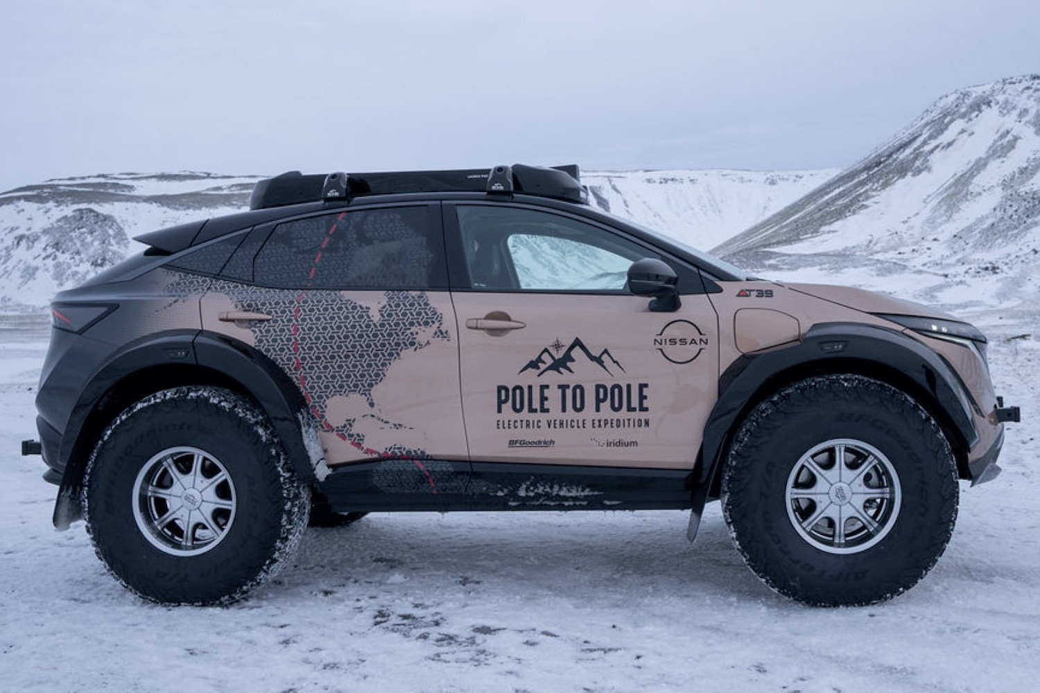 Side profile of Nissan Ariya parked on an icy road in front of snowy mountains.