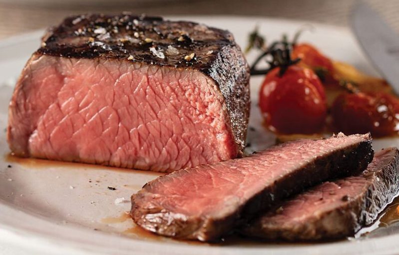 Omaha Steaks butcher's cut filet mignon closeup sliced on a plate.