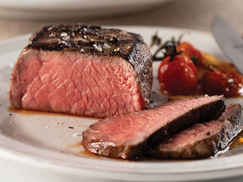 Omaha Steaks butcher's cut filet mignon closeup sliced on a plate.