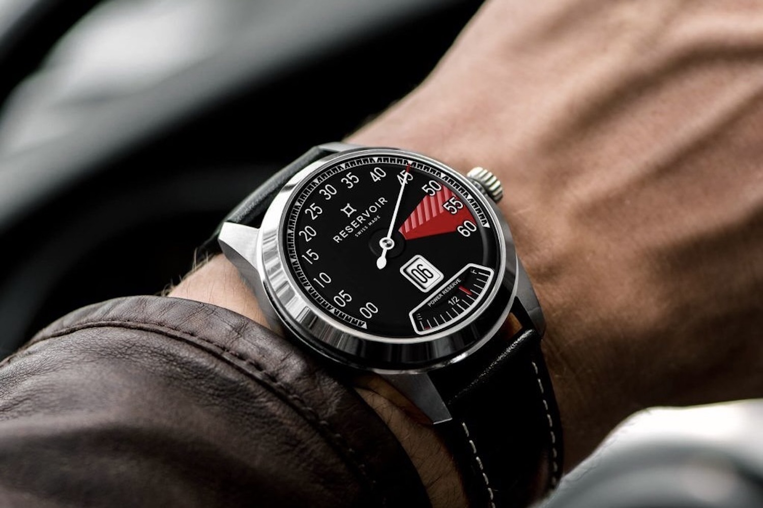Reservoir Supercharged Sport Red Zone on a man's wrist next to a leather jacket in a classic car.