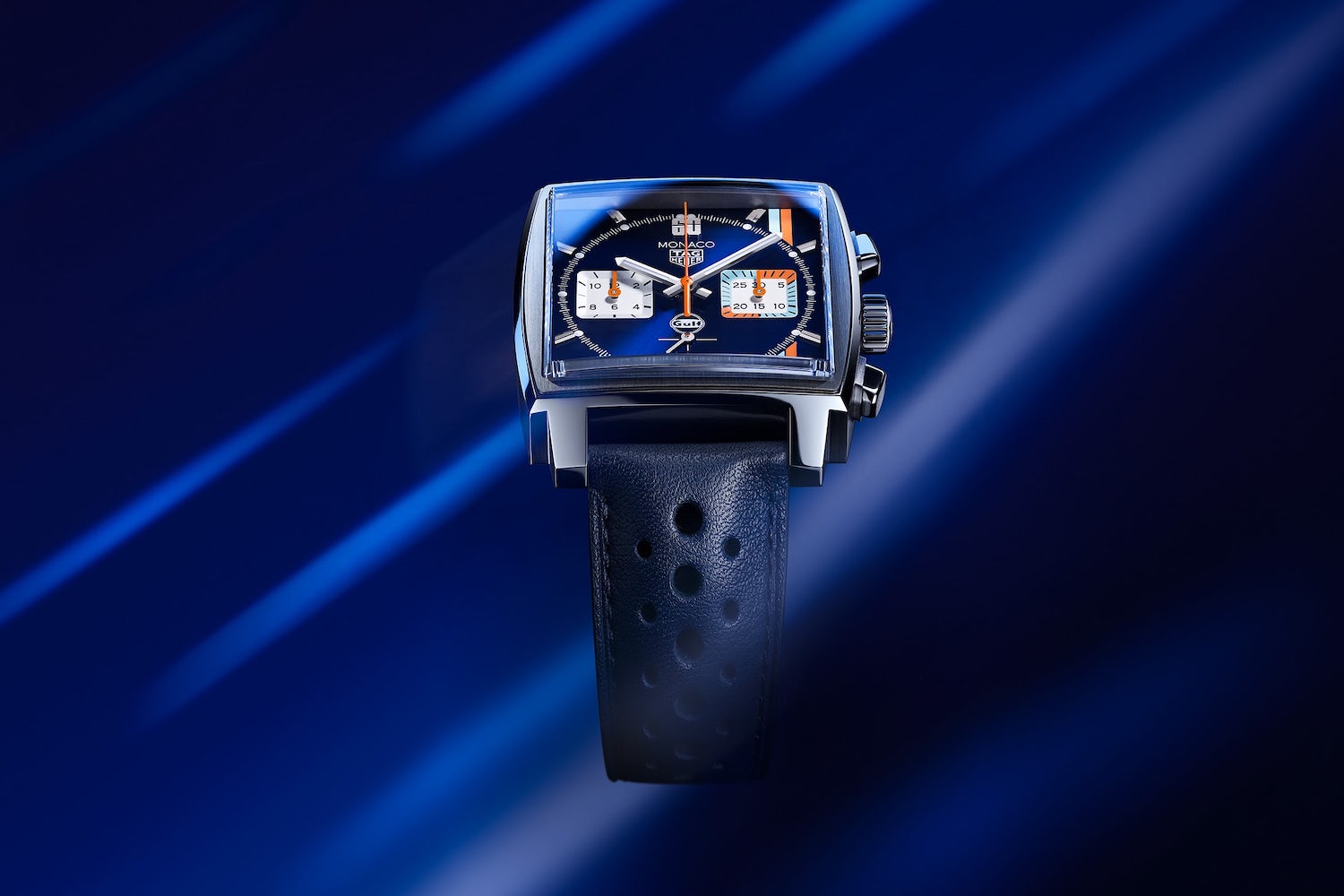 Tag Heuer Monaco X Gulf floating in a blue screen with lines in the back.