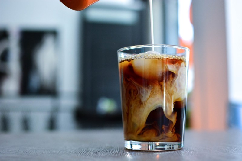 Pouring cream in cold brew coffee