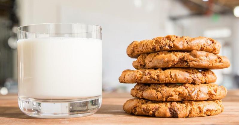 A stack of cookies with a glass of milk