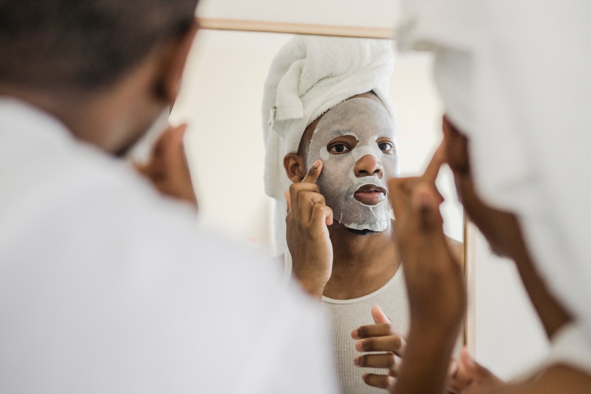 A man applying a skincare treatment in the mirror