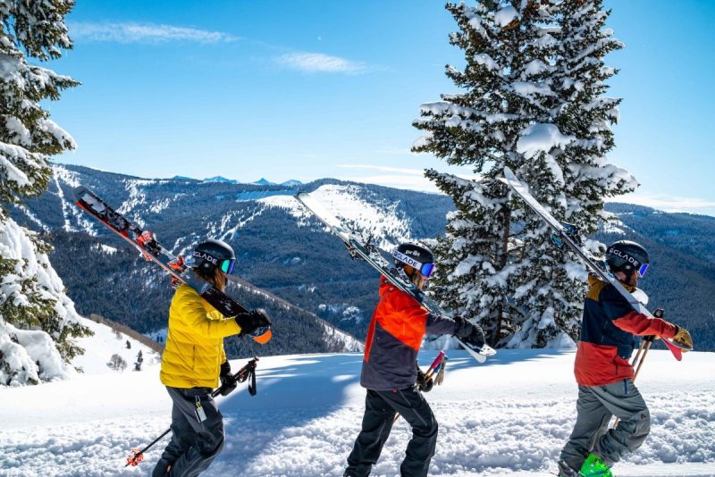 A group of friends walking in the snow to go skiing.