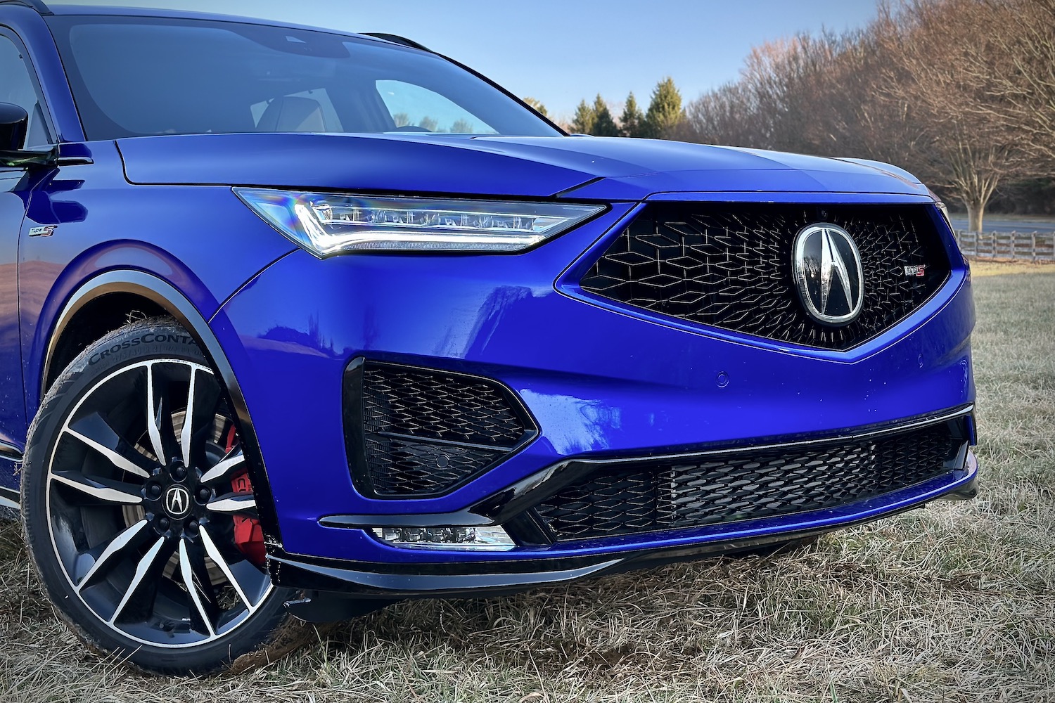 Close up of front end of the 2022 Acura MDX Type S parked in a hay field with trees in the back.