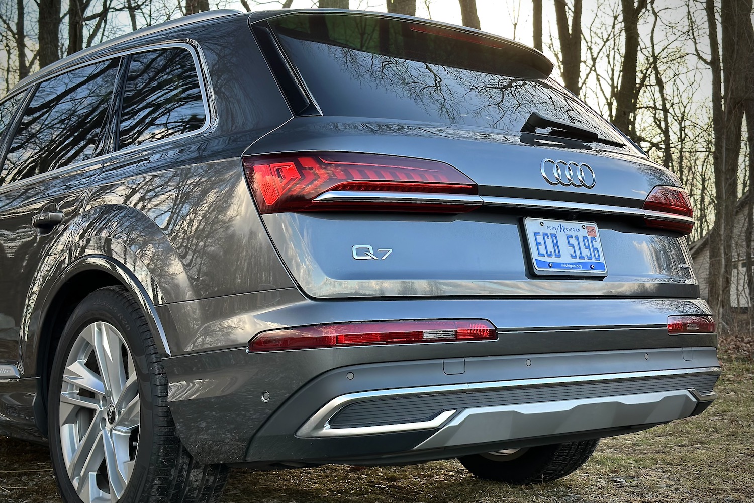 Rear end close up of the 2022 Audi Q7 Prestige parked in front of trees.