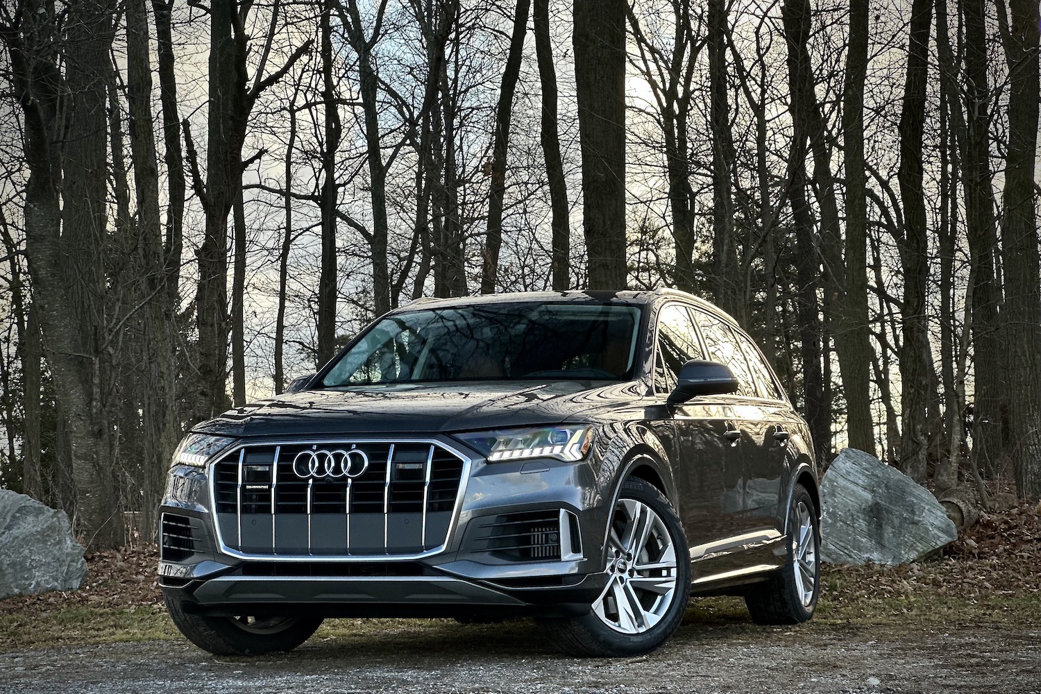 Front end angle of the 2022 Audi Q7 Prestige from driver's side parked in front of trees.