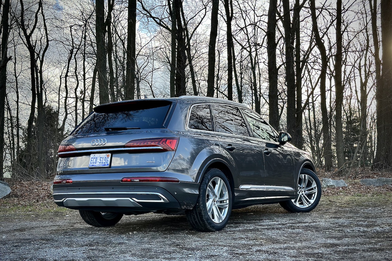 Rear end angle of the 2022 Audi Q7 Prestige from the passenger's side with trees in the back.