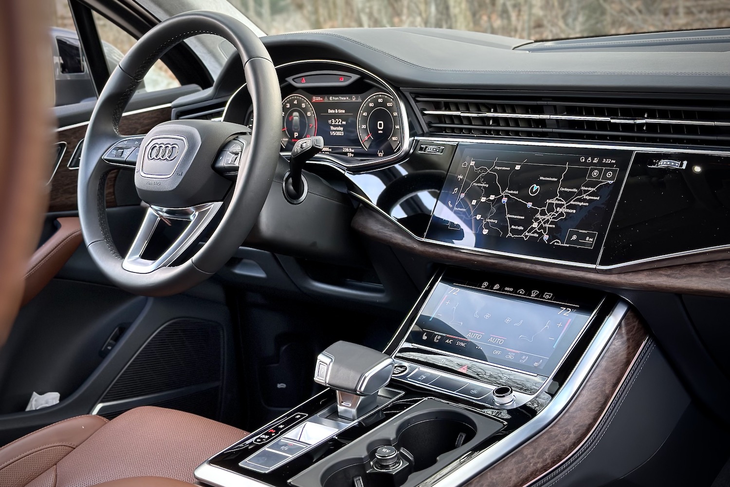 Dashboard, infotainment system, and steering wheel in the 2022 Audi Q7 Prestige from the rear seats.