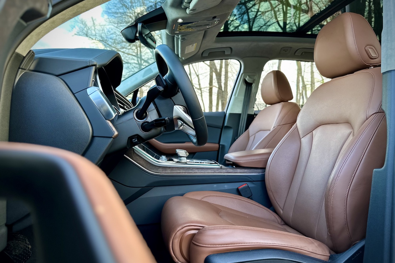 Front seats in the 2022 Audi Q7 Prestige from the driver's side with trees in the back.
