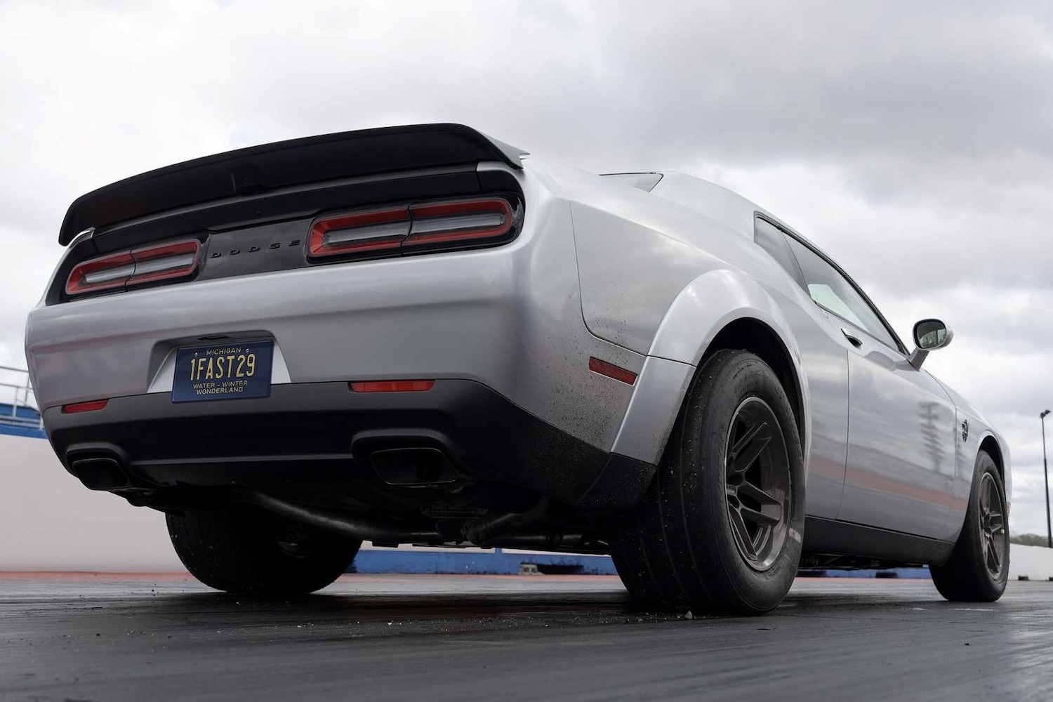 Rear end close up of the 2023 Dodge Challenger SRT Demon 170 on a drag strip with clouds in the back.