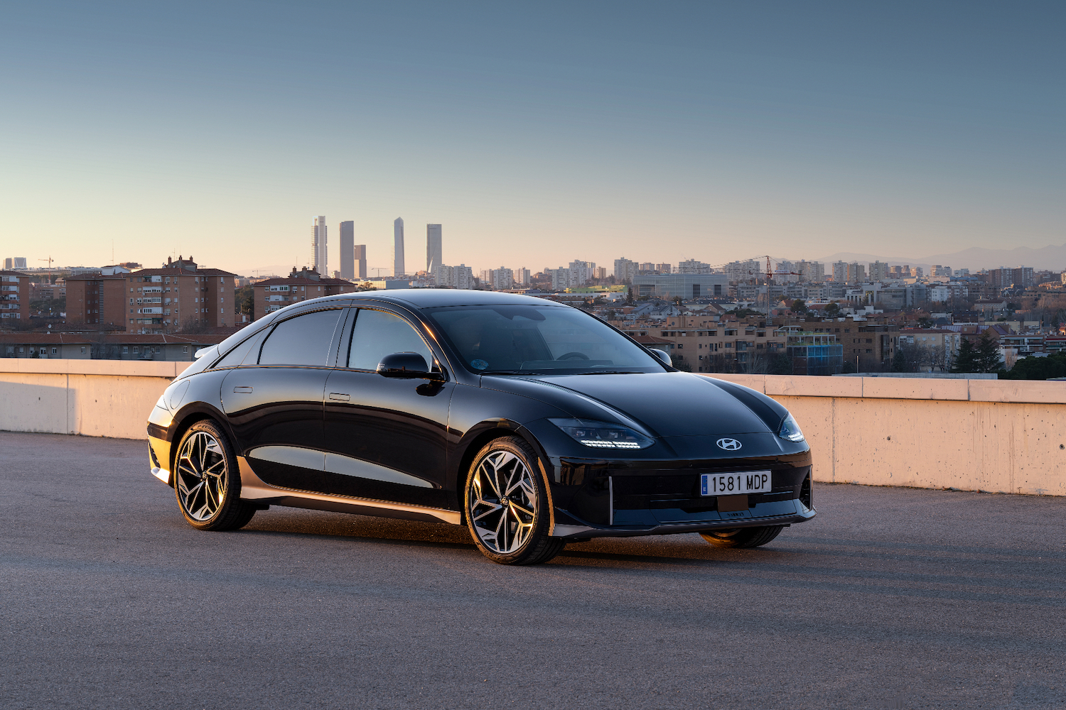 2023 Hyundai Ioniq 6 front end angle from passenger's side with a city in the back.
