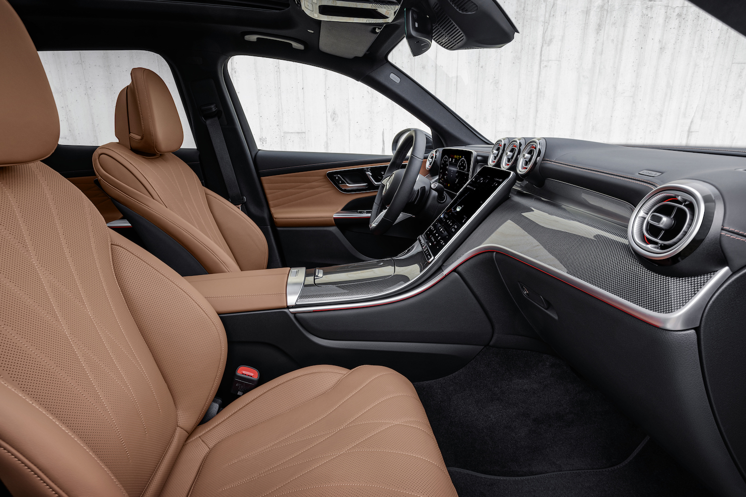 Close up of dashboard in the 2023 Mercedes-Benz GLC from outside the passenger side in front of a white wall.