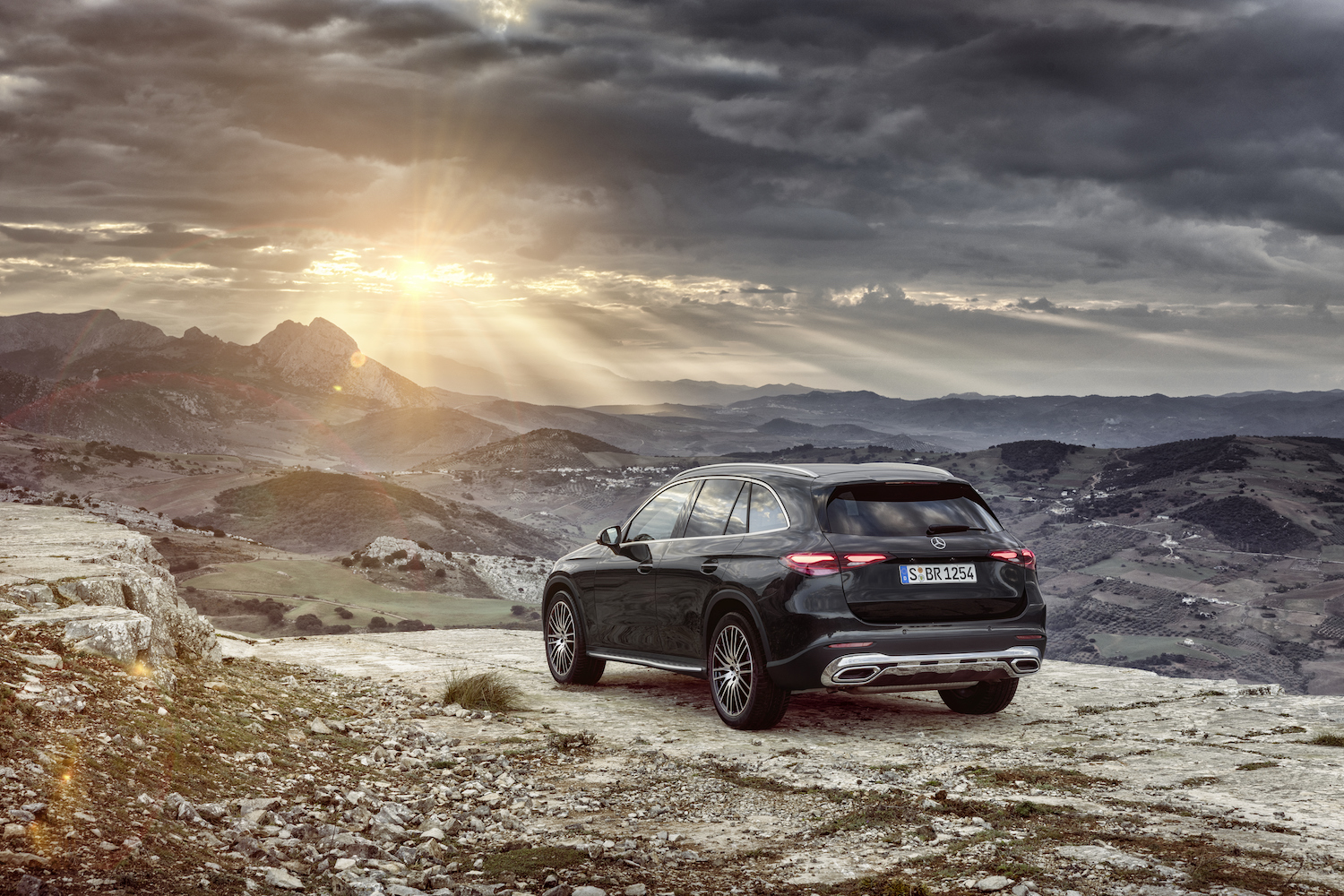 2023 Mercedes-Benz GLC rear end angle from driver's side parked in front of mountains at sunset.