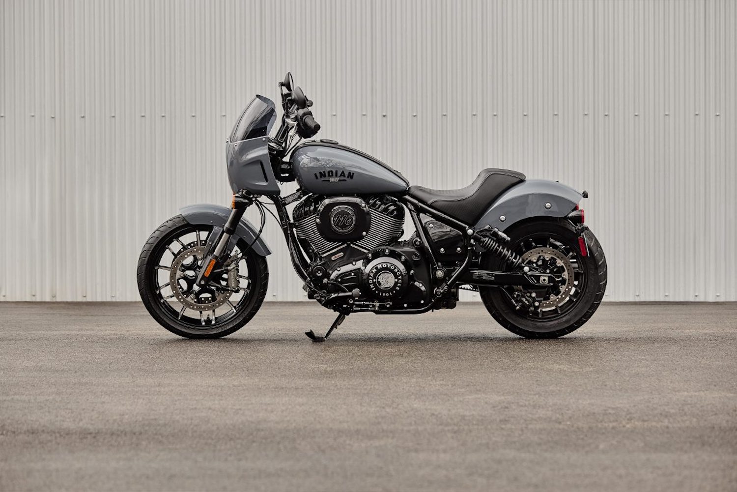 Side profile view of the 2023 Indian Sport Chief parked in front of a wall on a concrete pad.