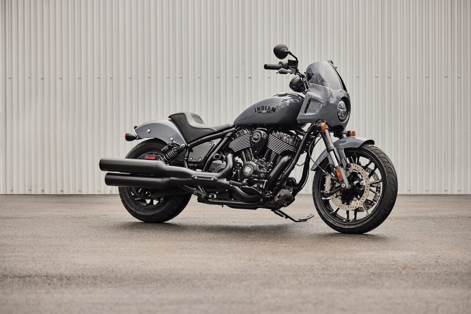 Front end angle of the 2023 Indian Sport Chief parked in front of a wall.