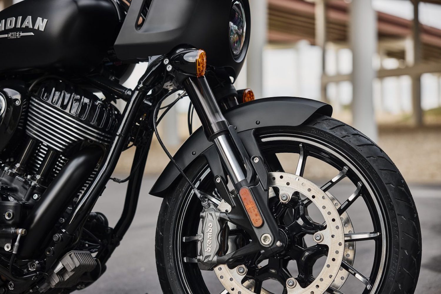 Close up of front forks, wheel, and brakes on the 2023 Indian Sport Chief with an underpass in the back.