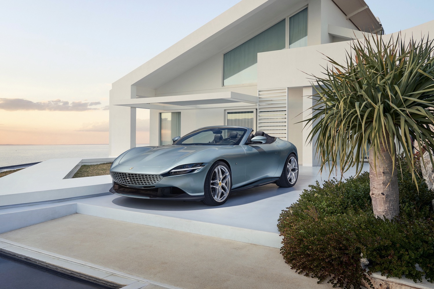 Front end angle of the 2024 Ferrari Roma from the driver's side parked in front of a mansion.