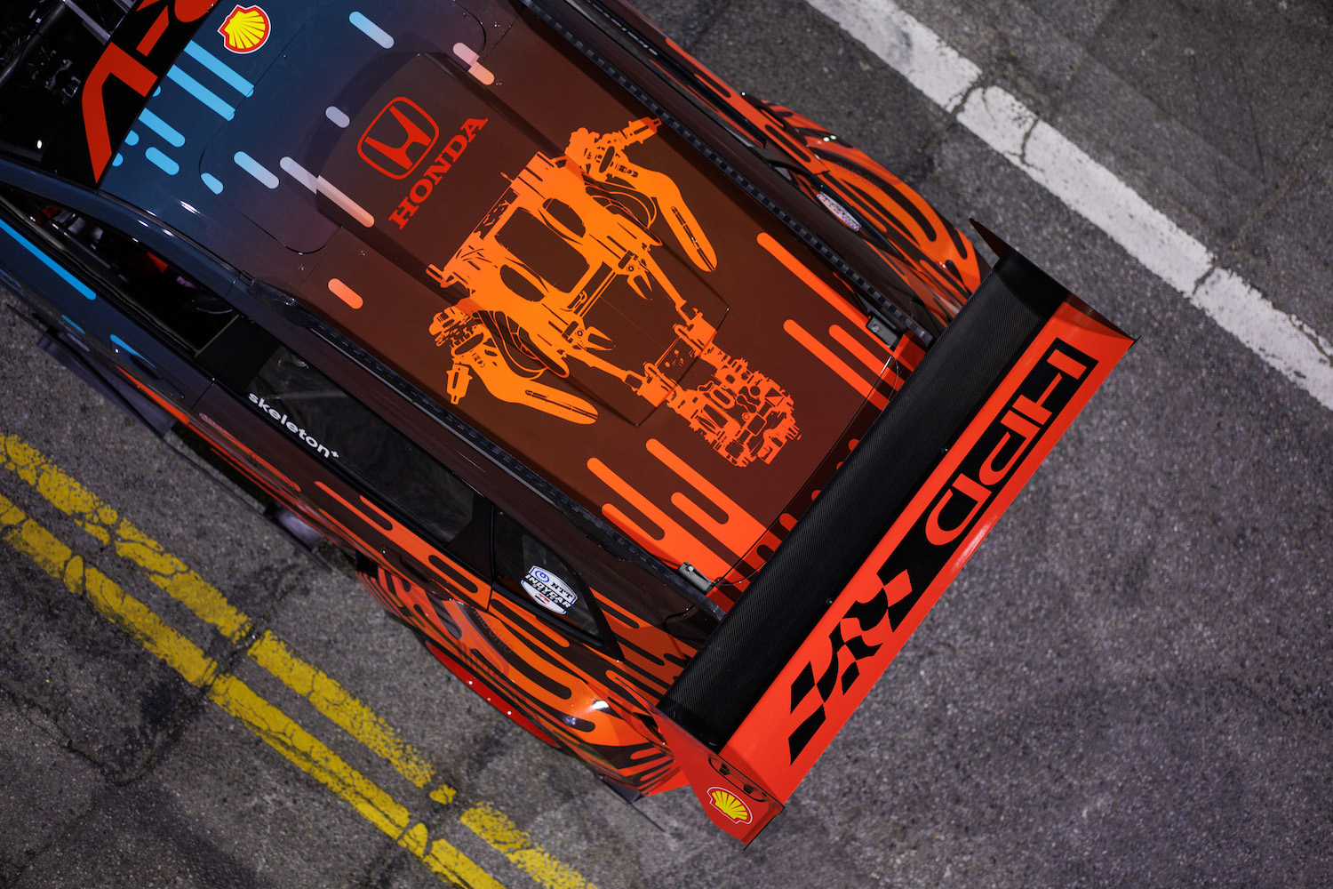 Overhead shot of the rear end of the Honda CR-V Hybrid Racer parked in the middle of the street at night.