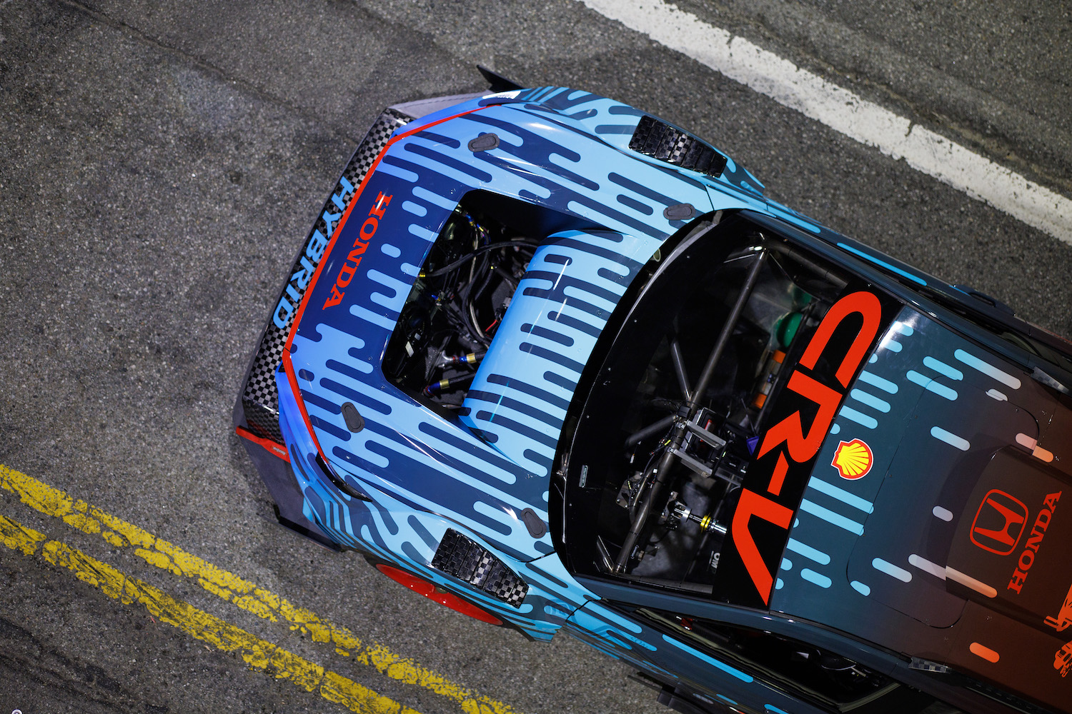 Overhead shot of the front end of the Honda CR-V Hybrid Racer parked in the middle of the steet at night.