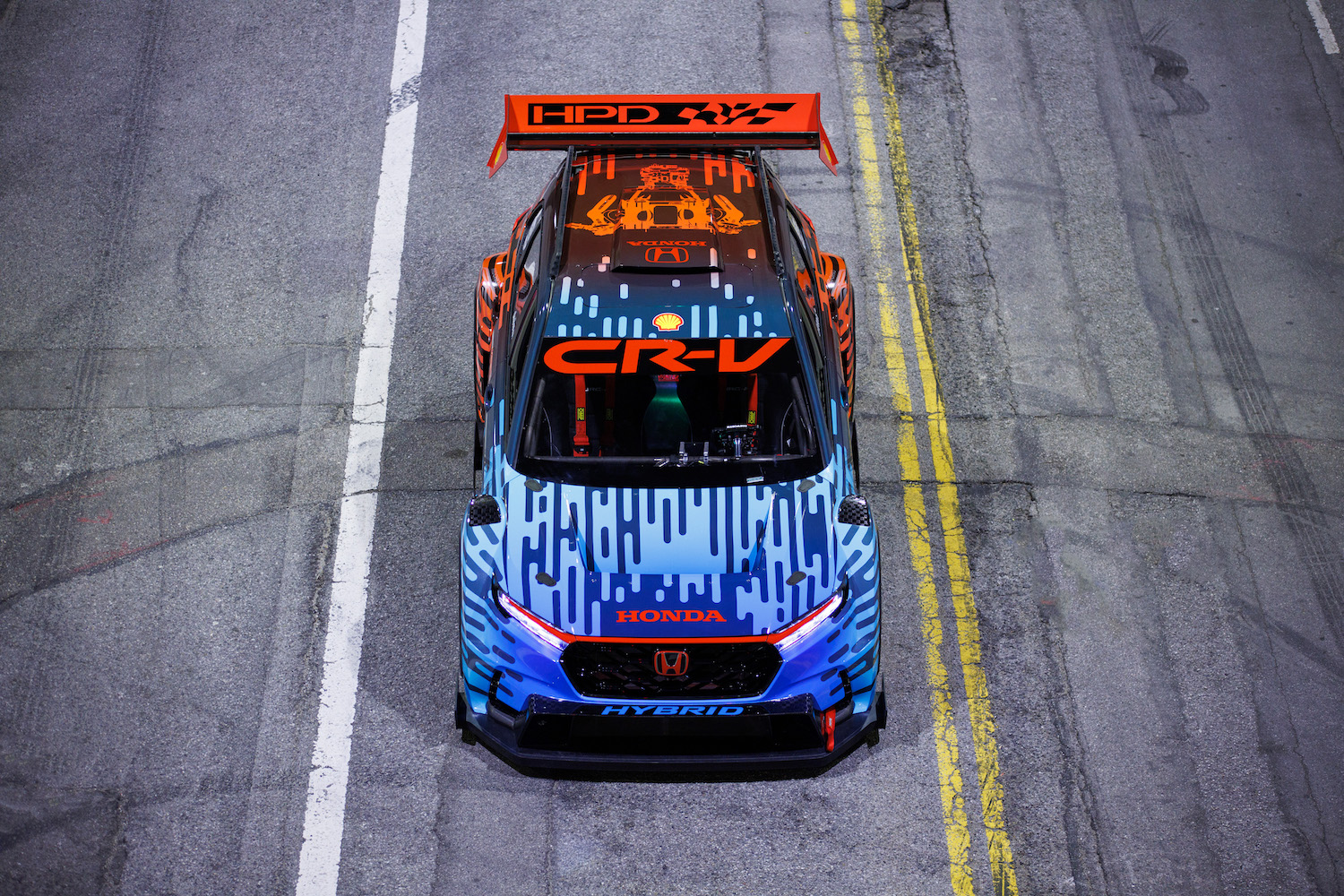 Overhead front end angle of the Honda CR-V Hybrid Racer parked in the middle of the street at night.