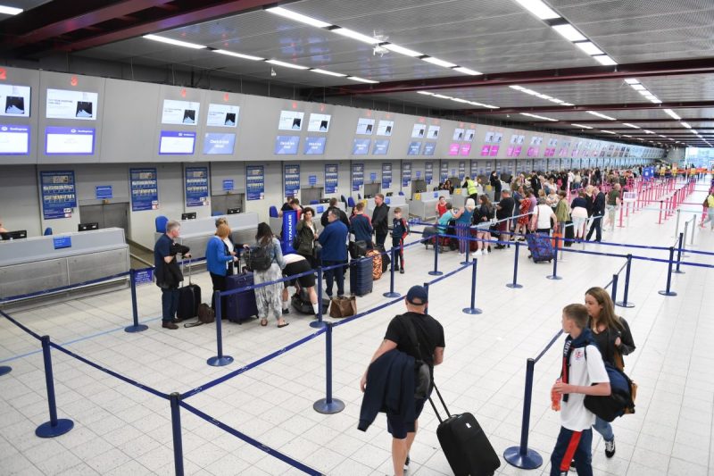 A busy airport with people getting in line at check in.