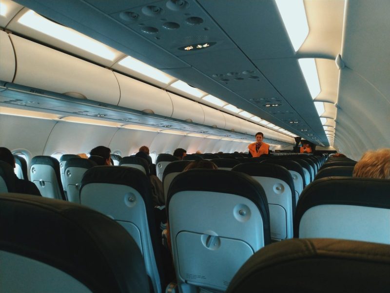 The inside of a plane with the passengers seated.