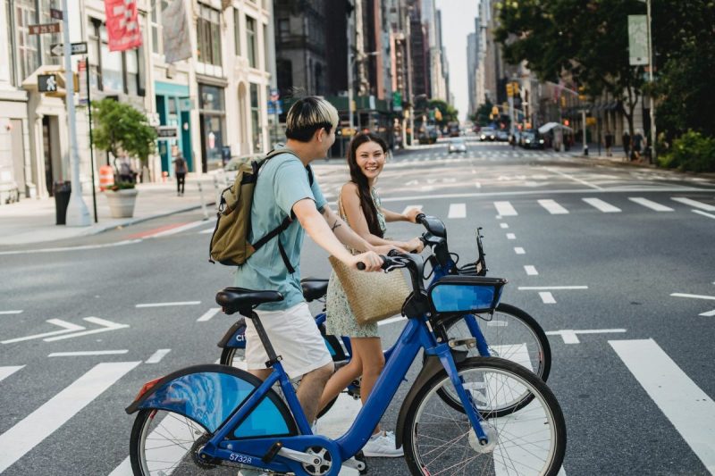 People crossing the street in the city, walking their bikes