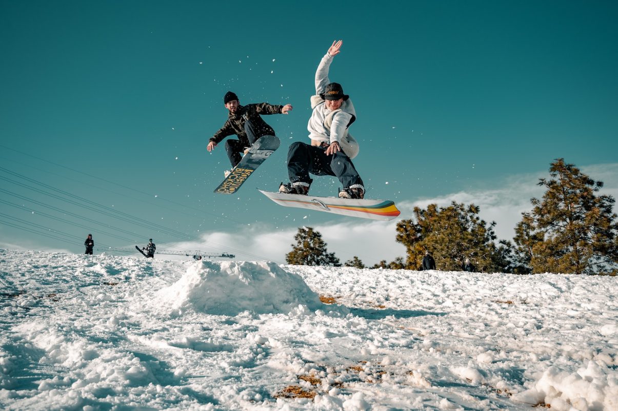 People doing jumps on snowboard in the snow.