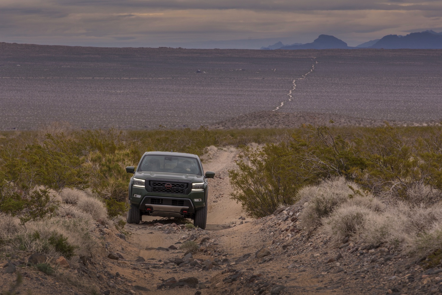 Front end of the 2022 Nissan Frontier Pro-4X parked on a trail in the desert.
