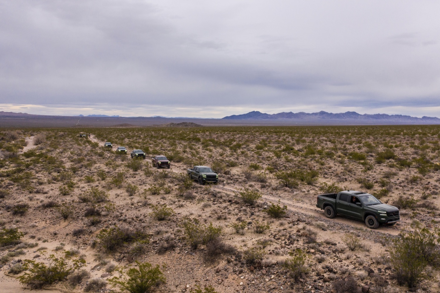 Overhead photo of the 2022 Nissan Frontier Pro-4X off-roading through the desert with dark clouds above.