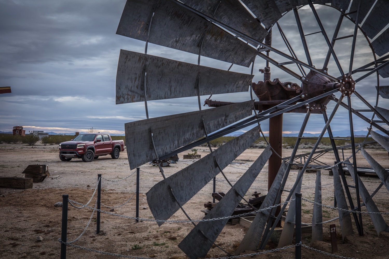 2022 Nissan Frontier Pro-4X front end angle parked behind a windmill on a dirt trail.